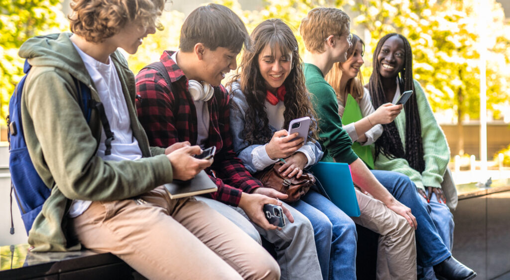 Happy multicultural group of people using smartphone outdoors young people having fun together while watching social media
