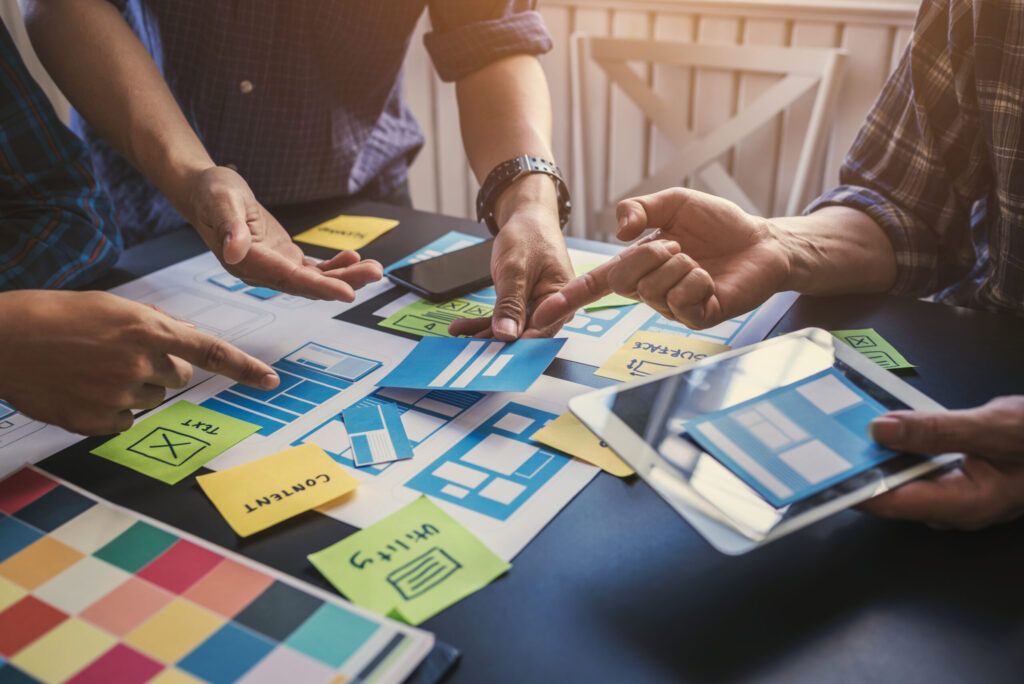 Ux/ui team of designers helping to create content and forms of mobile applications to make it easier for users to use.