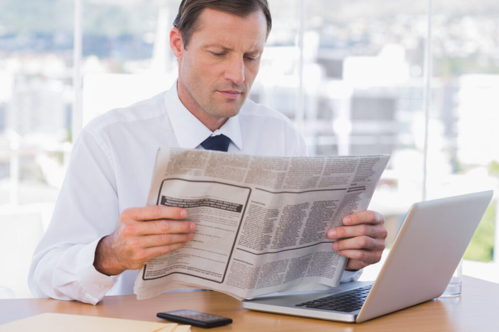 Businessman reading a newspaper in his office
