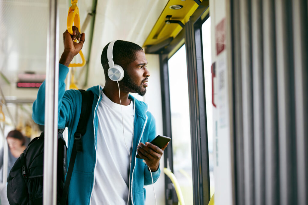 Man using phone, listening music traveling in train