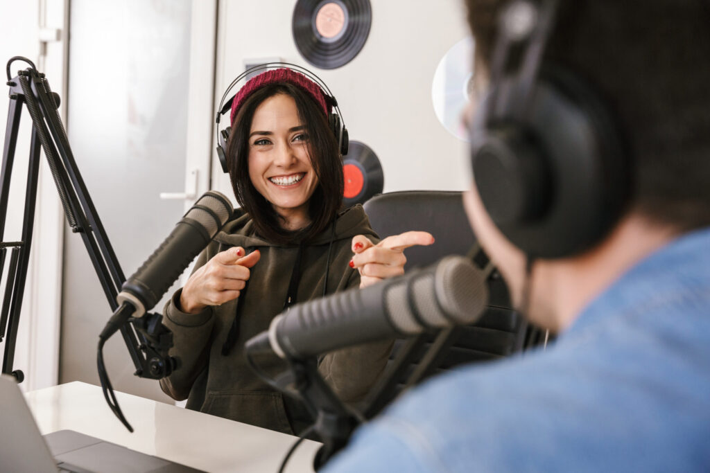 Man and woman in white shirts podcasters interview